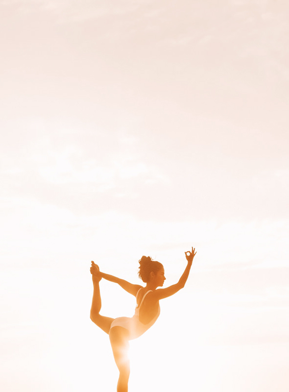 Woman practicing yoga during sunset